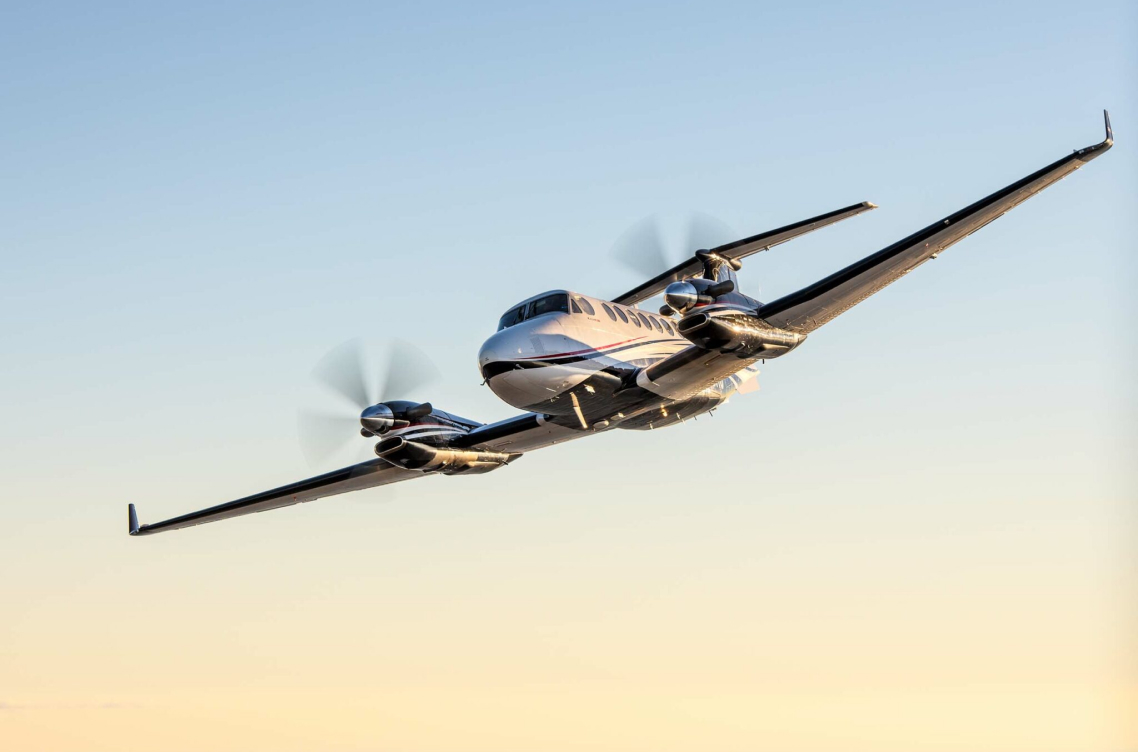 airplane with propellers flying over sunset