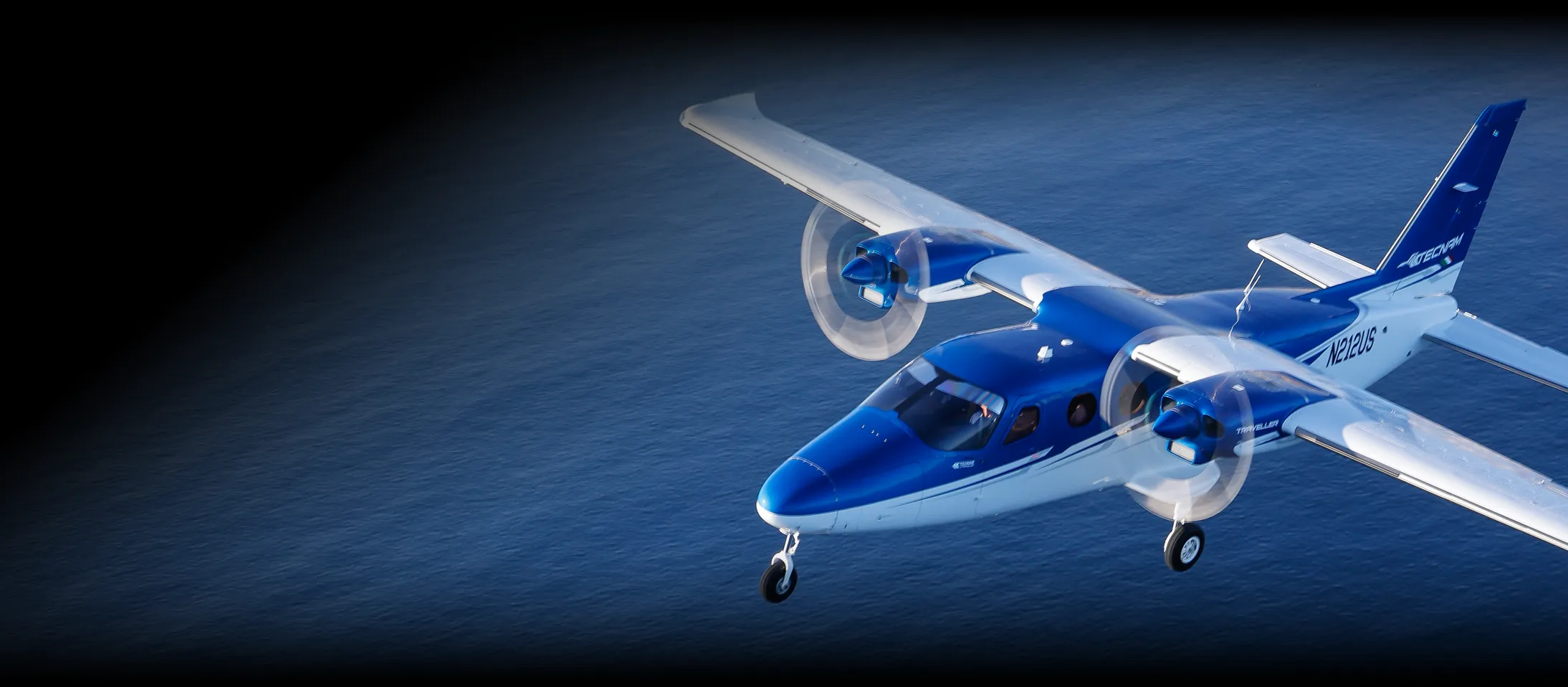 P2012 Traveller in flight over water.
